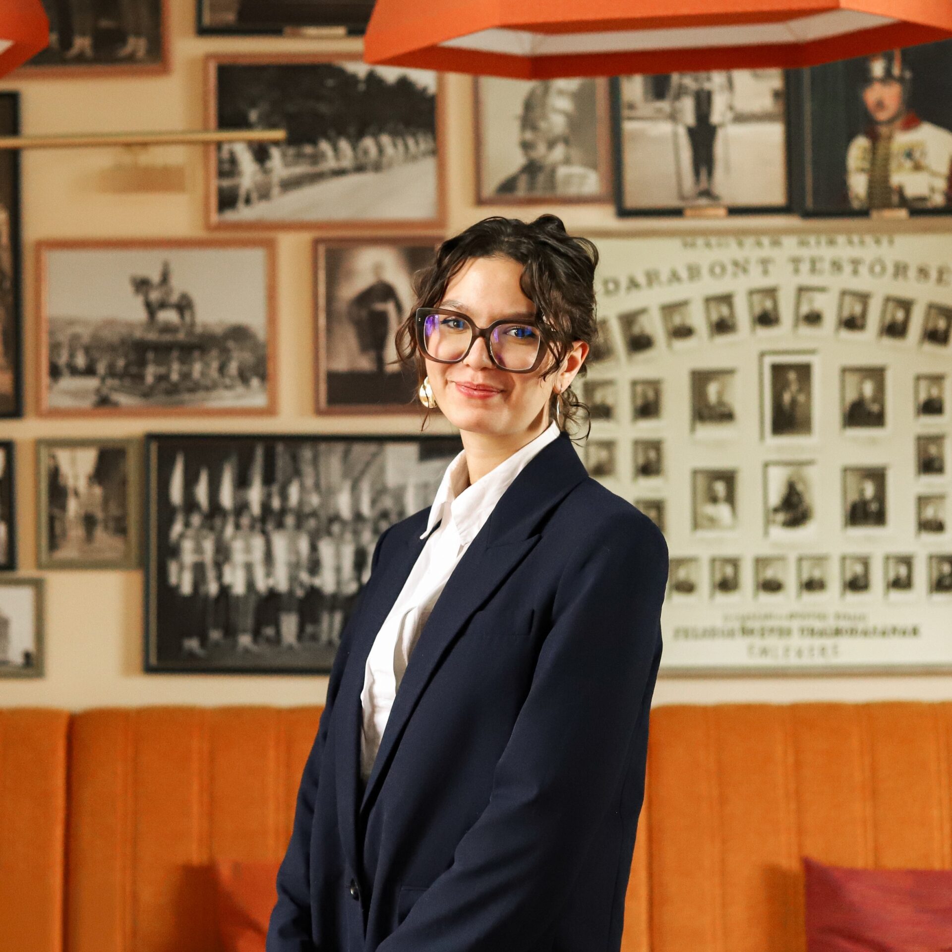 Főőrség Rendezvénytere terített asztalokkal, gyertyatartókkal és faliképekkel a háttérben